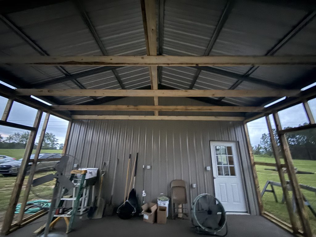 The enclosed end of the pavilion taking shape, with the pond visible past the open side